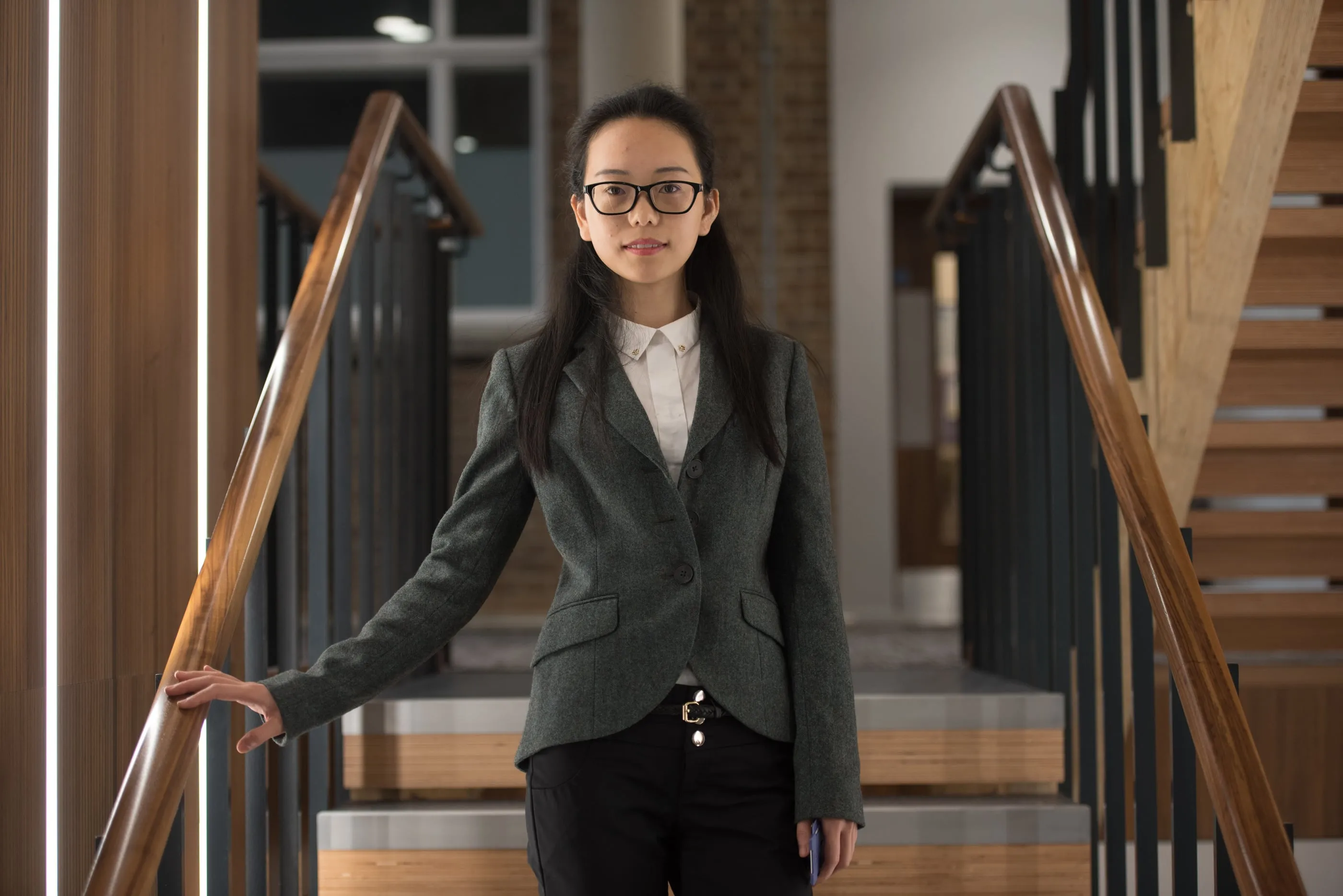 An environmental portrait photographed on a staircase in a Cambridge building