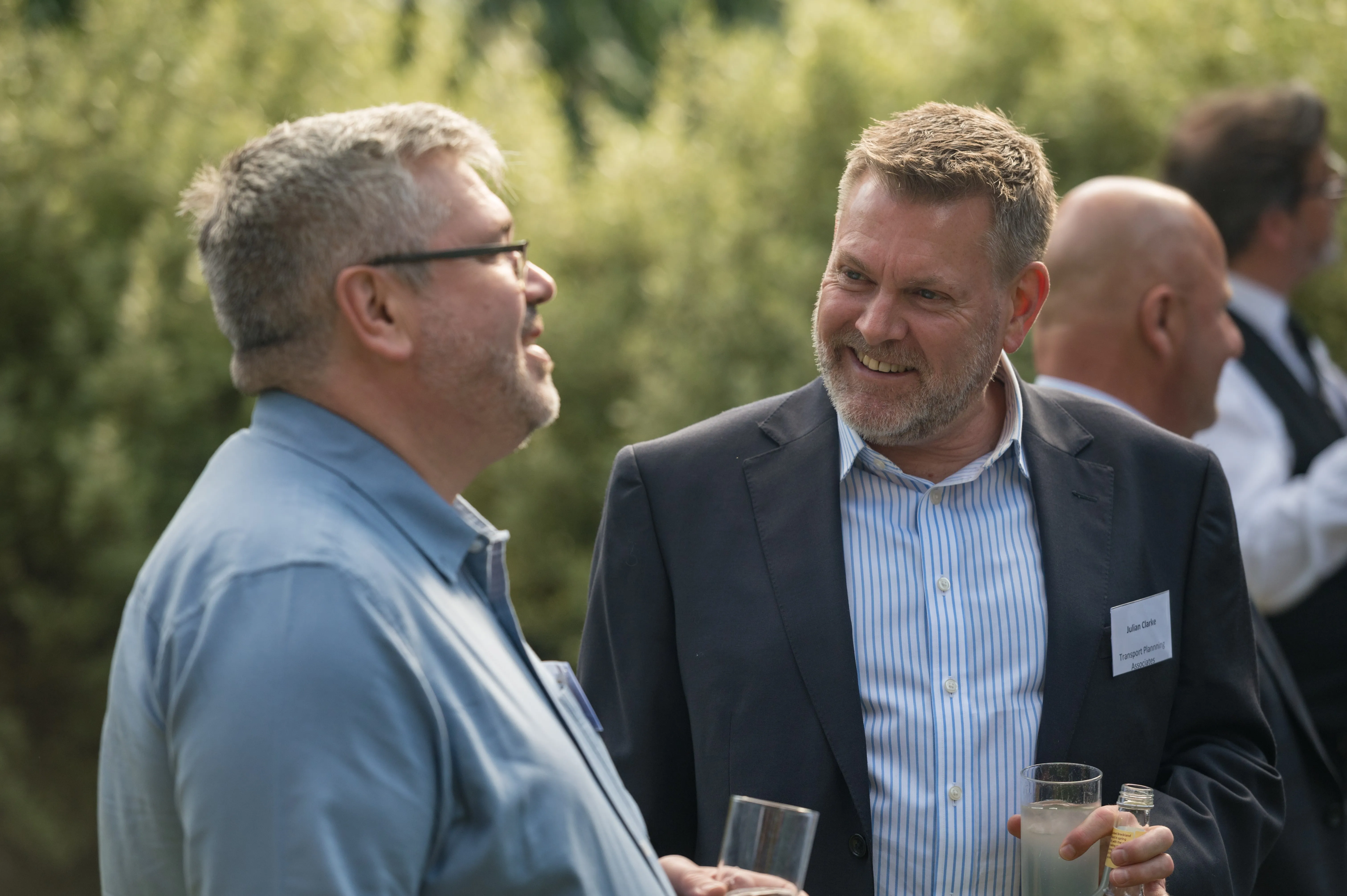 Two delegates in conversation at an outdoor drinks reception