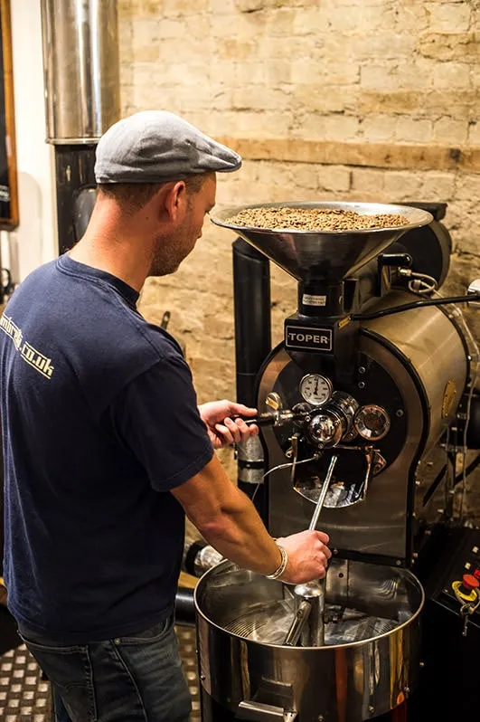 A coffee roaster at work at the roasting machine