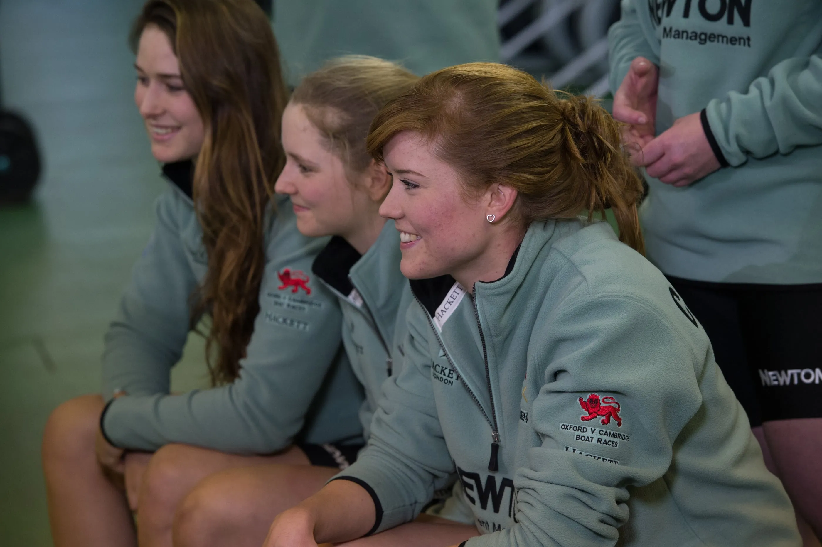 Members of a rowing club sitting together in team kit