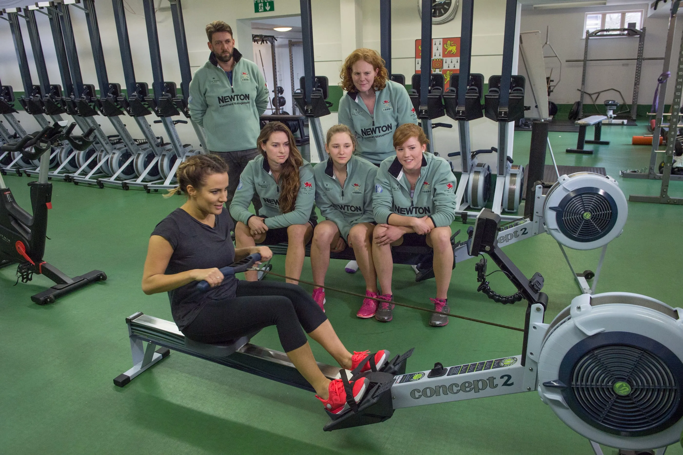 Athletes training on rowing machines in a gym