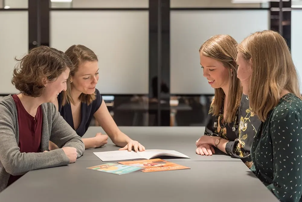 Colleagues working through printed documents around a table