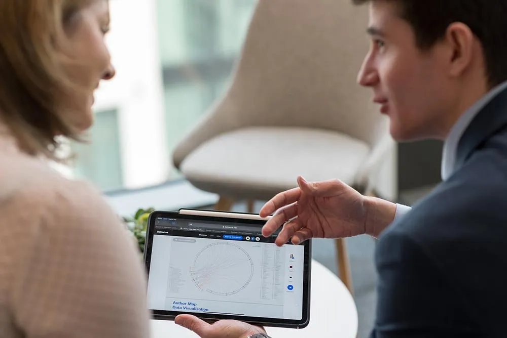 Two colleagues talking over a tablet