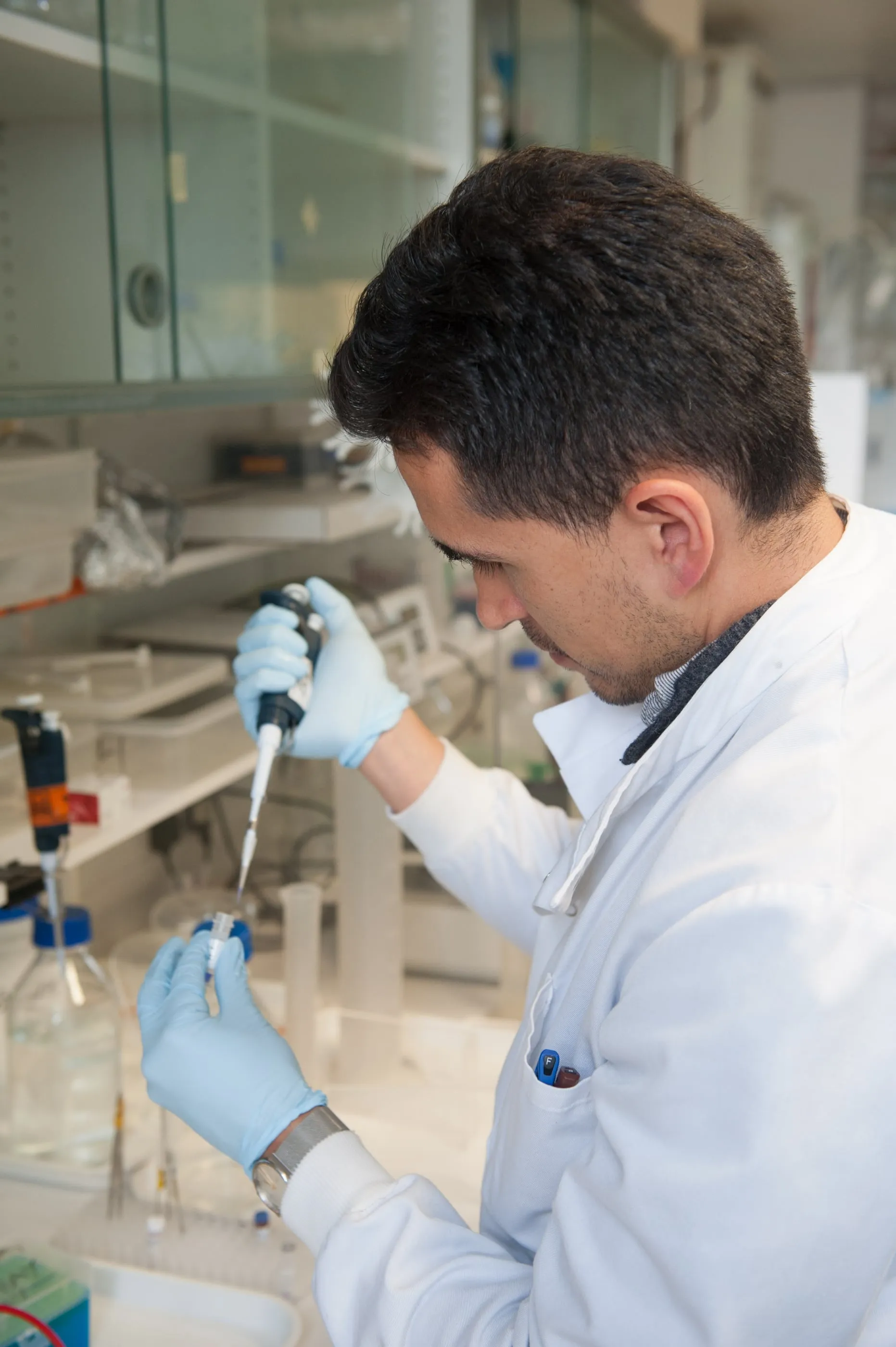 A scientist working at a laboratory bench in Cambridge, photographed with a shallow depth of field